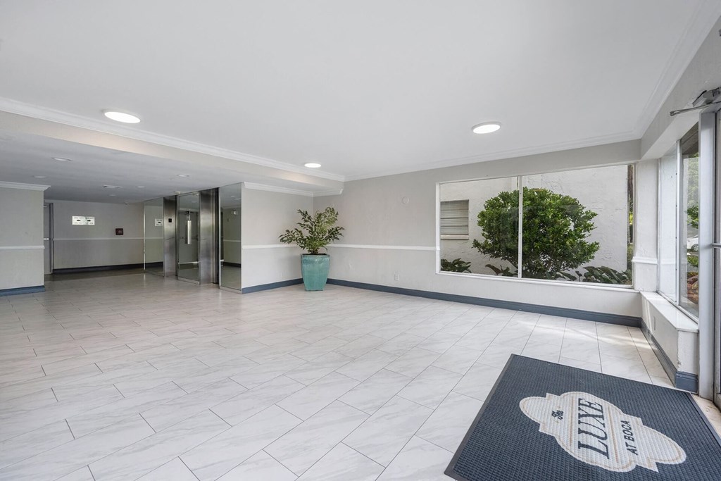 A hallway with a black and white rug on the floor.