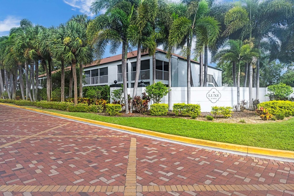 A white building with a sign that says "LANE" in front of some palm trees.