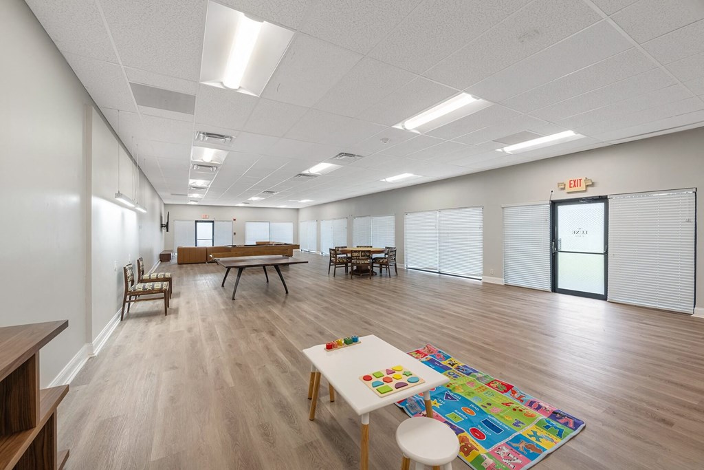 A room with a white table and chairs, a puzzle on the table, and a white rug.