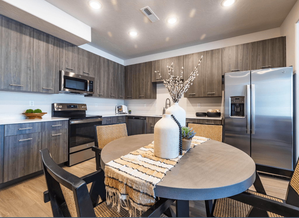 A modern kitchen with a dining table set for two.