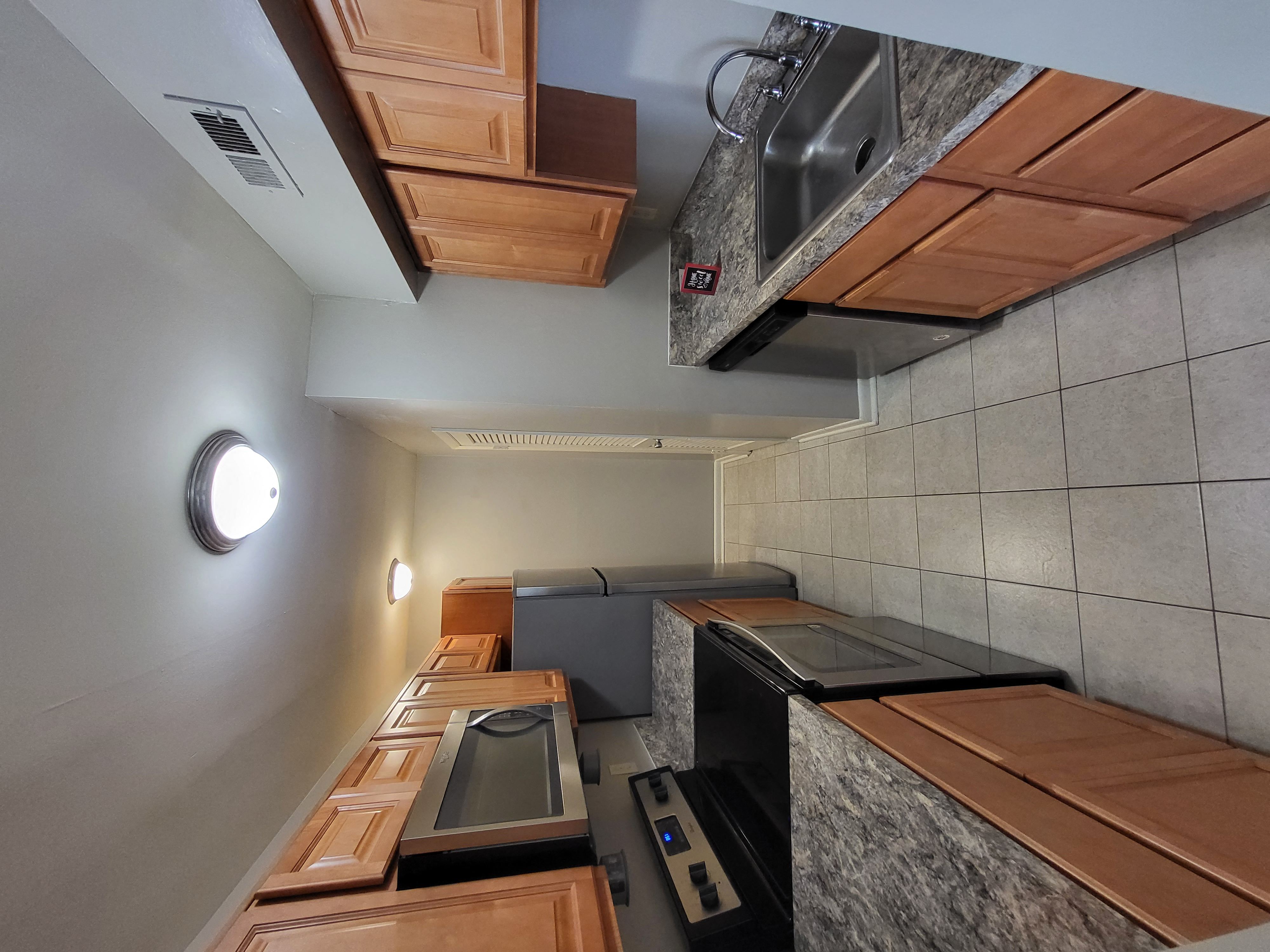a kitchen with a stove top oven next to a sink