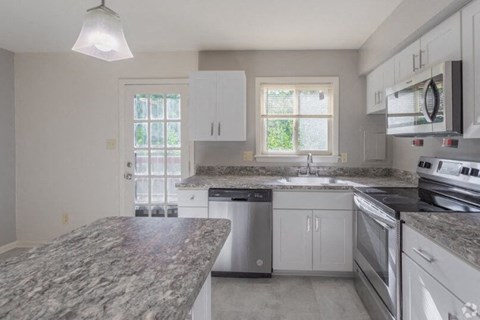 a kitchen with a stove a sink and a microwave