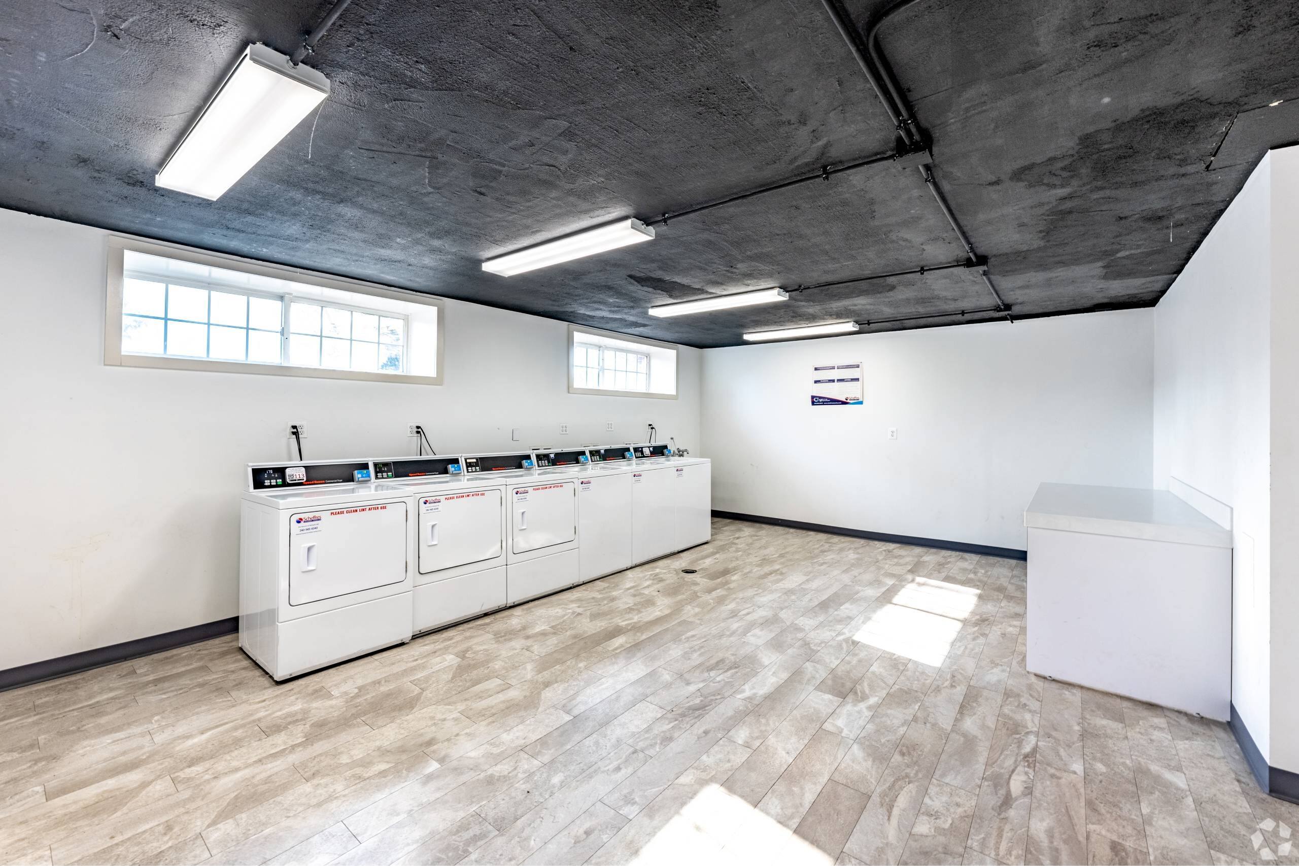 A room with a row of white machines on the wall.