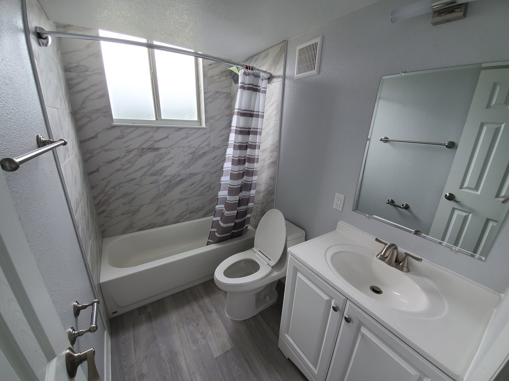 A bathroom with a toilet, sink, and bathtub.