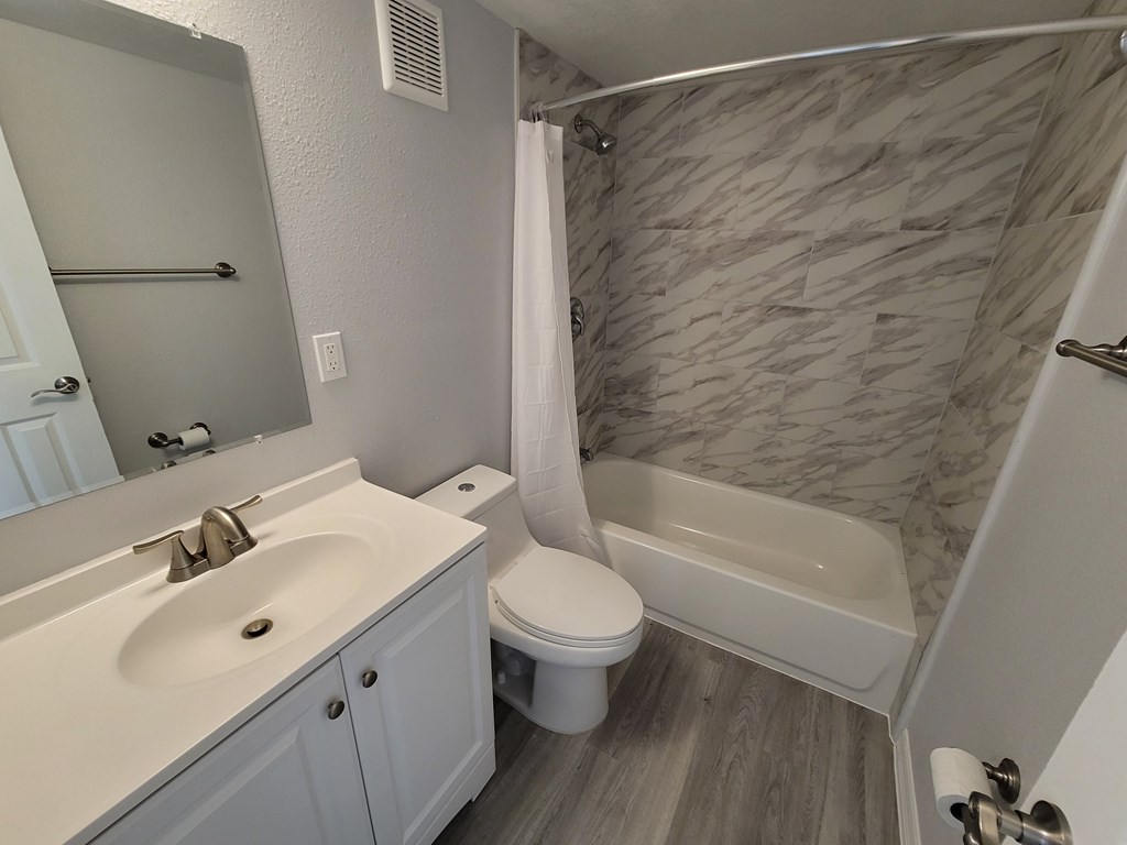 A bathroom with a white sink, toilet, and bathtub.