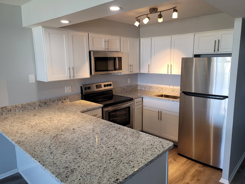 A kitchen with granite countertops and stainless steel appliances.