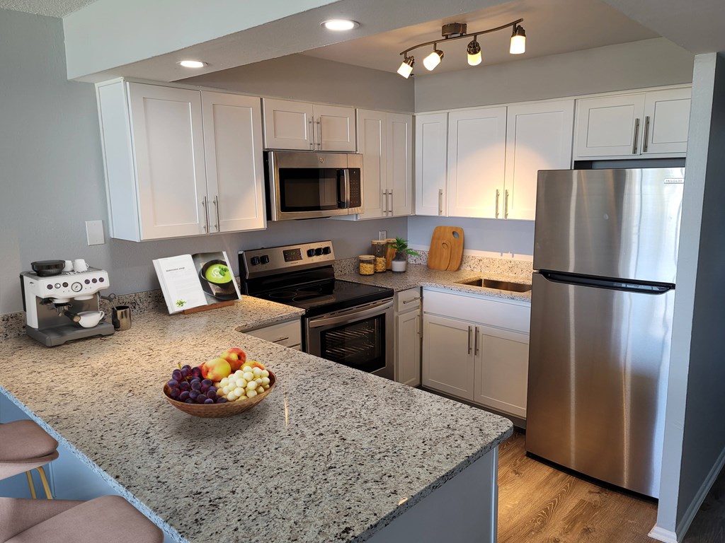 A kitchen with a granite countertop and stainless steel appliances.