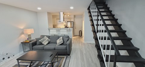 A living room with a grey couch and a black coffee table.