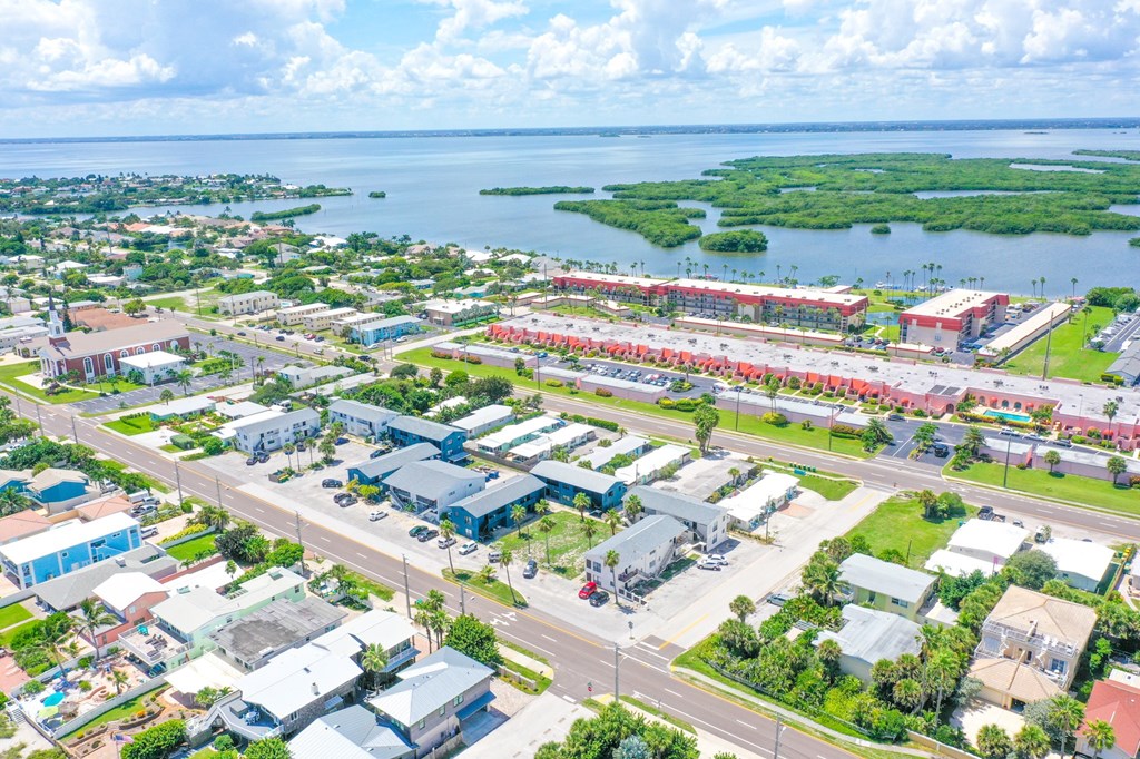 A bird's eye view of a city with buildings, roads, and a body of water.