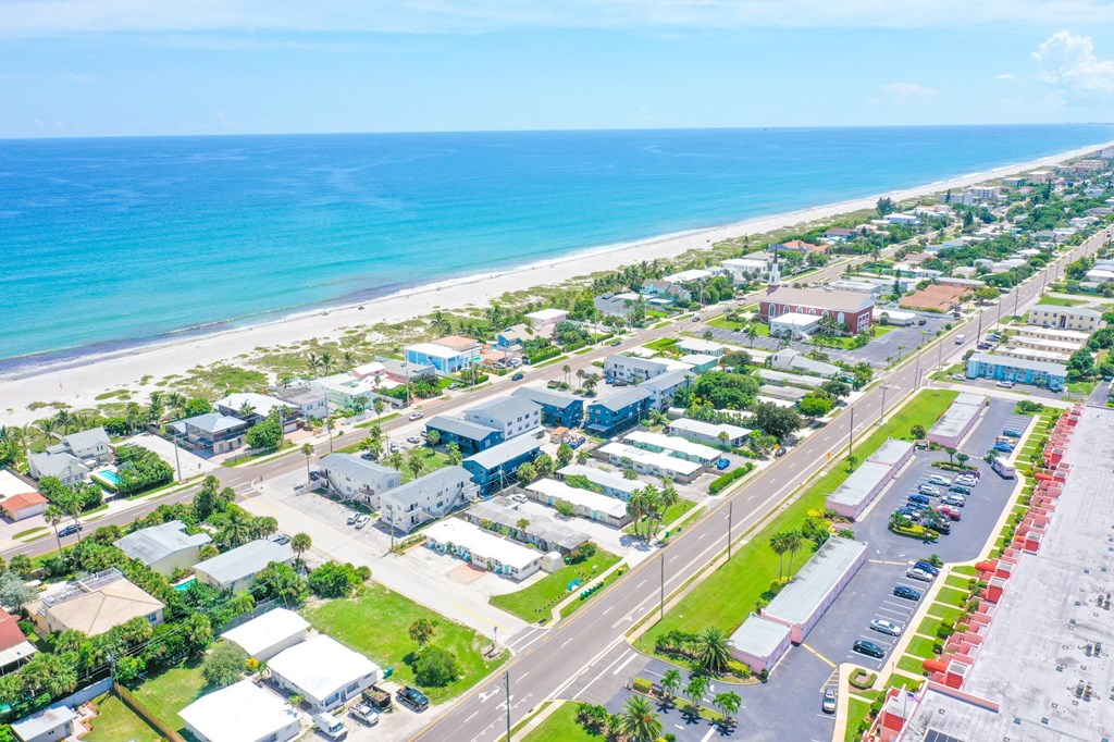 A beachfront town with a parking lot in the foreground.