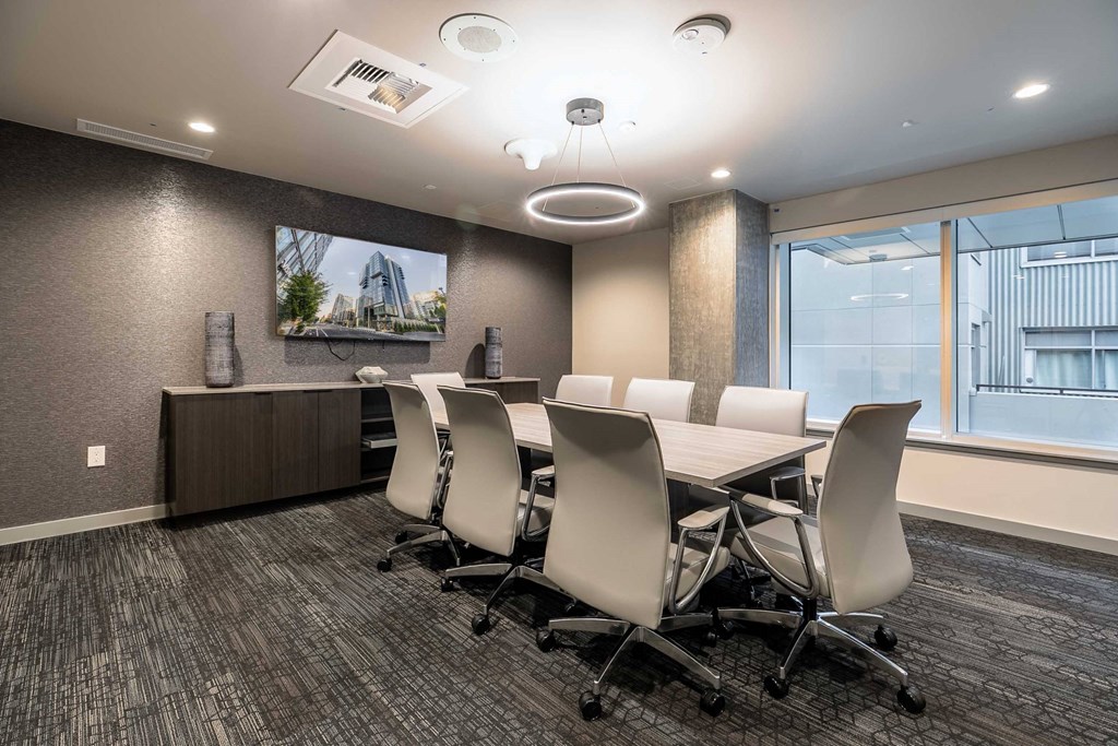 A conference room with a long table and chairs.