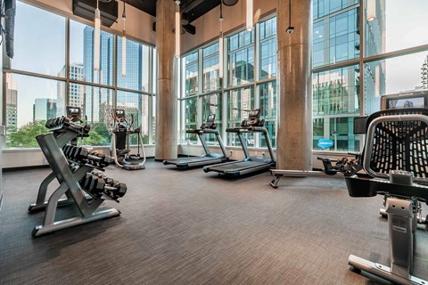 A gym with treadmills, weights, and exercise equipment.