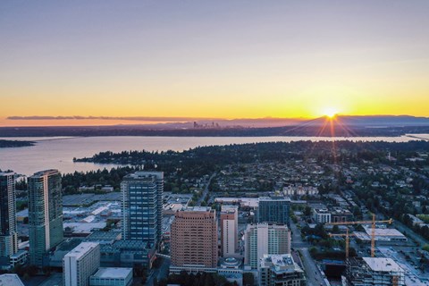 A cityscape with buildings and a sunset in the background.