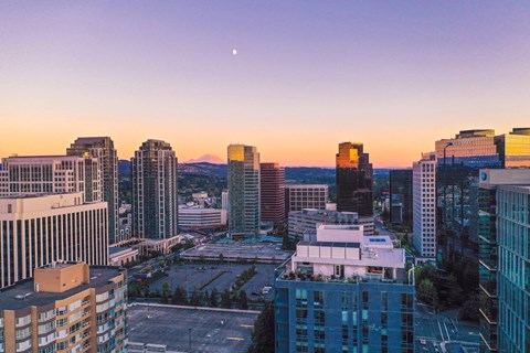 A cityscape at dusk with buildings and a clear sky.