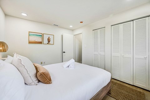 A bedroom with a large bed and a wardrobe.