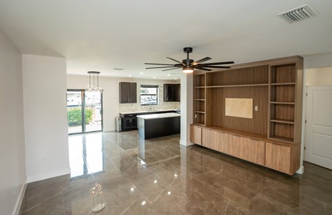 A spacious room with a ceiling fan and a large wooden cabinet.