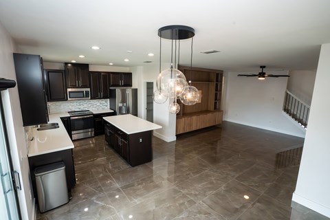 A modern kitchen with a black refrigerator and a wooden island.