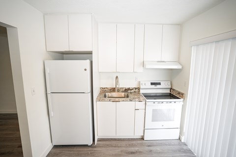 A kitchen with white appliances and cabinets.
