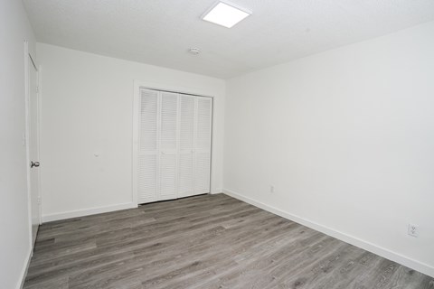 A room with a white door and a window with blinds.