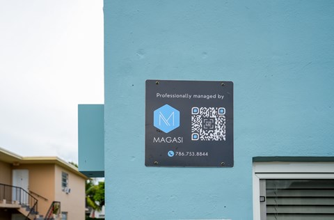 A sign on a building that says "Professionally managed by MAGASI" with a phone number.