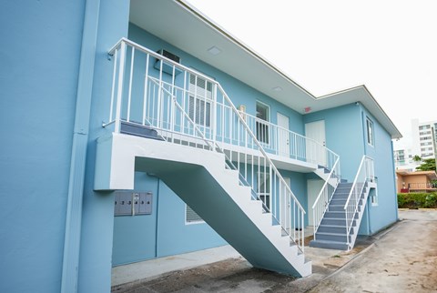 A blue building with a white staircase.