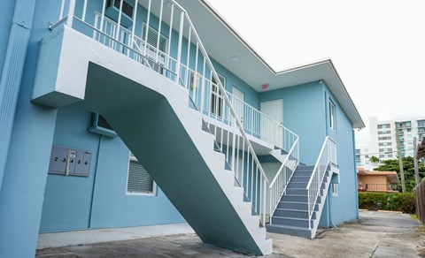 A blue building with a white staircase.
