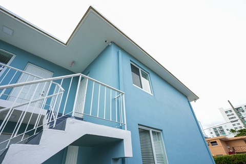 A blue house with a white balcony.