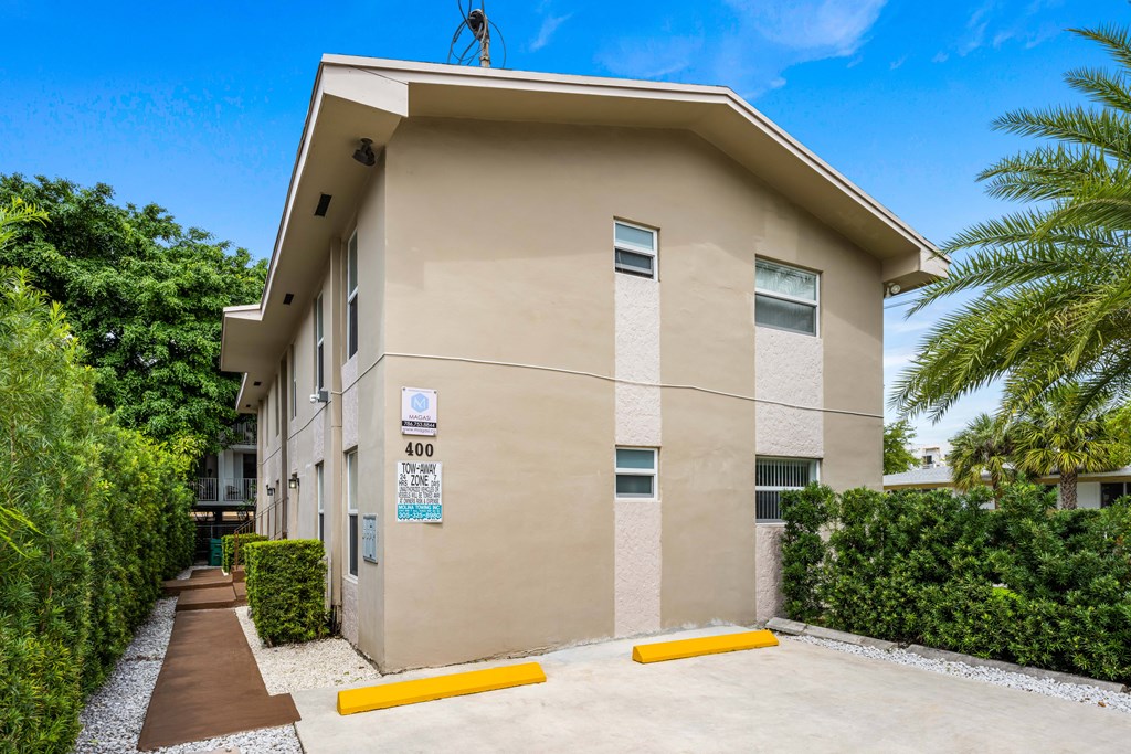 A beige building with a blue sign on the front.