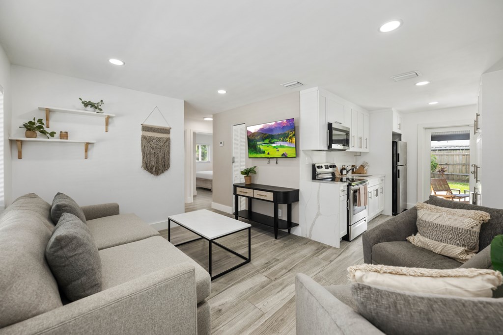 A living room with a grey couch and a white coffee table.