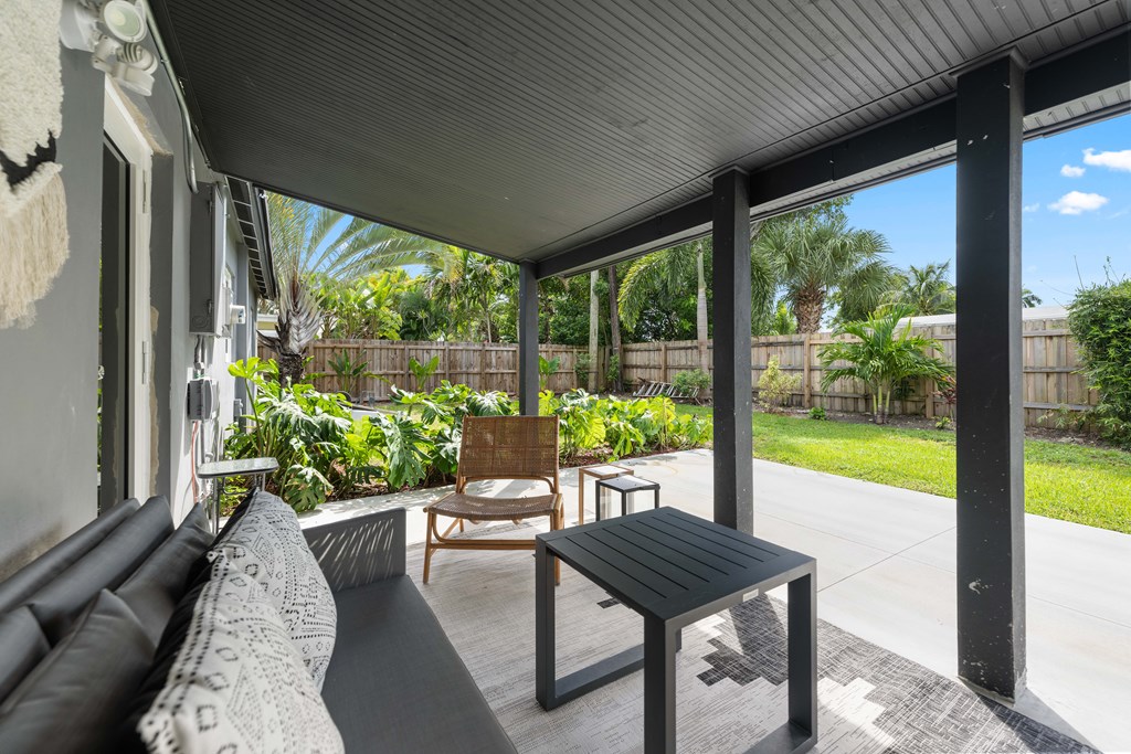 A patio with a black table and chairs.