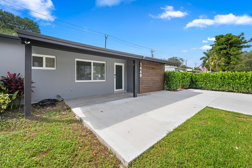A grey house with a black door and a grey roof.