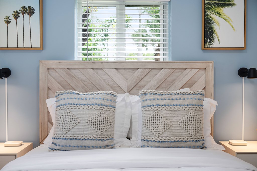 A bed with two pillows and a white headboard.