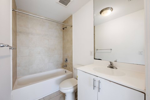 A white bathroom with a toilet, sink, and bathtub.