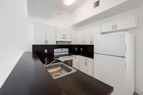 A kitchen with black countertops and white cabinets.