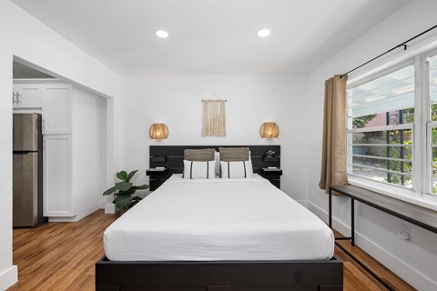A bedroom with a large bed and a window with a view of the outside.