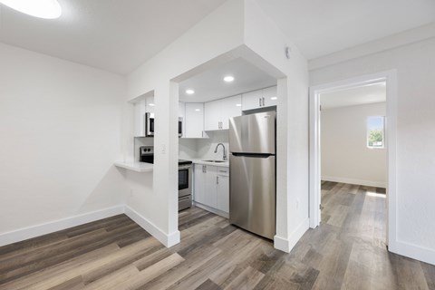 A kitchen with a refrigerator, microwave, and oven.