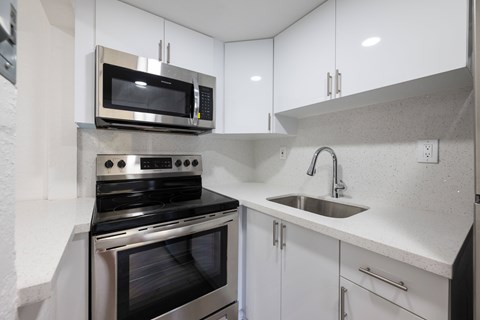 A modern kitchen with a stove, oven, and microwave.