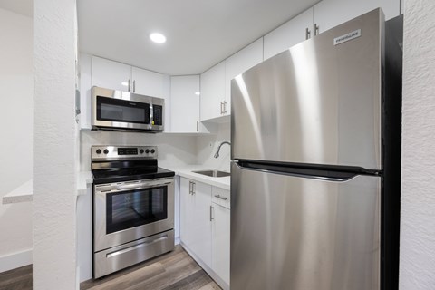 A modern kitchen with stainless steel appliances and white cabinetry.
