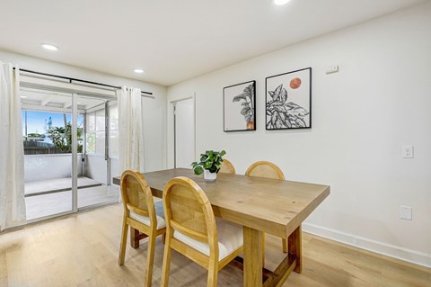 A dining room with a wooden table and chairs.