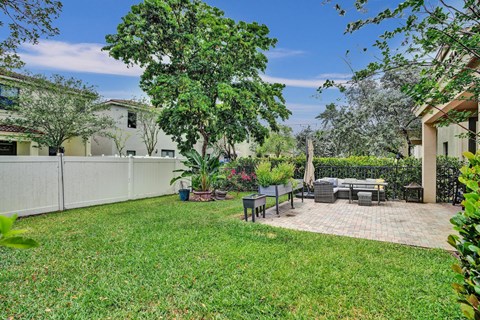 A backyard with a patio and a tree.
