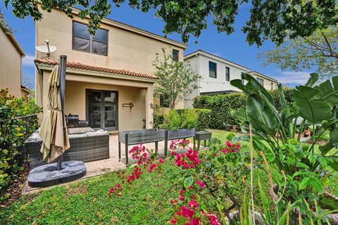 A house with a patio and a garden in front.