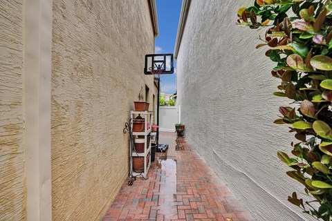 A brick pathway leads to a basketball hoop.