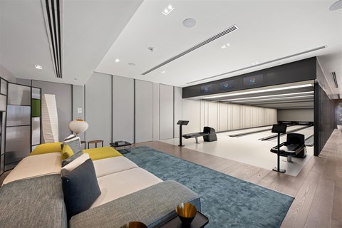 A modern living room with a grey sofa and yellow accent pillows.
