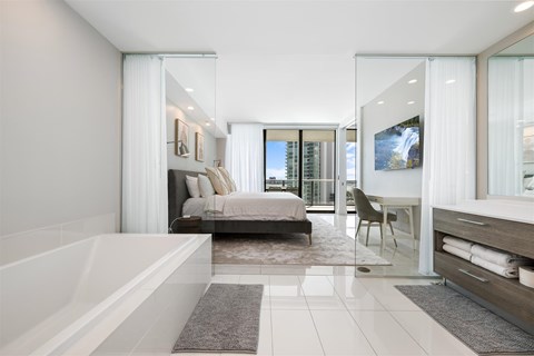 A modern bedroom with a large bed and a bathtub.