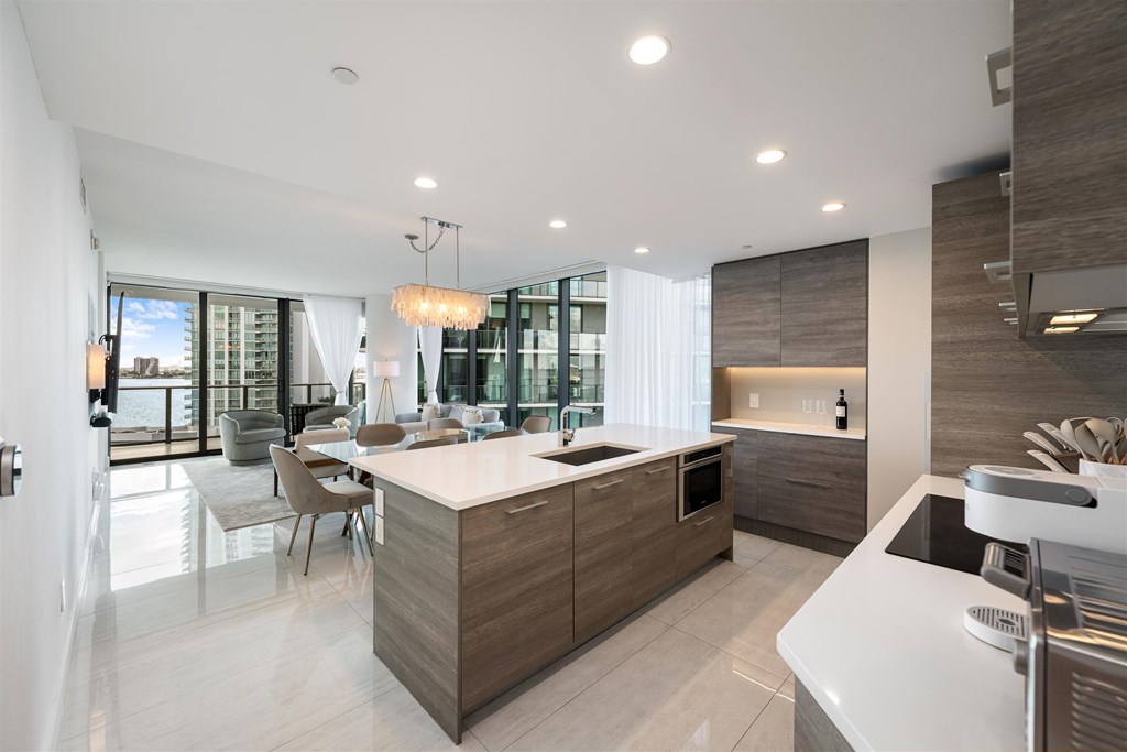 A modern kitchen with a large island and a dining area.