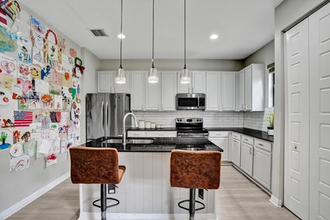 A kitchen with a black counter top and white cabinets.