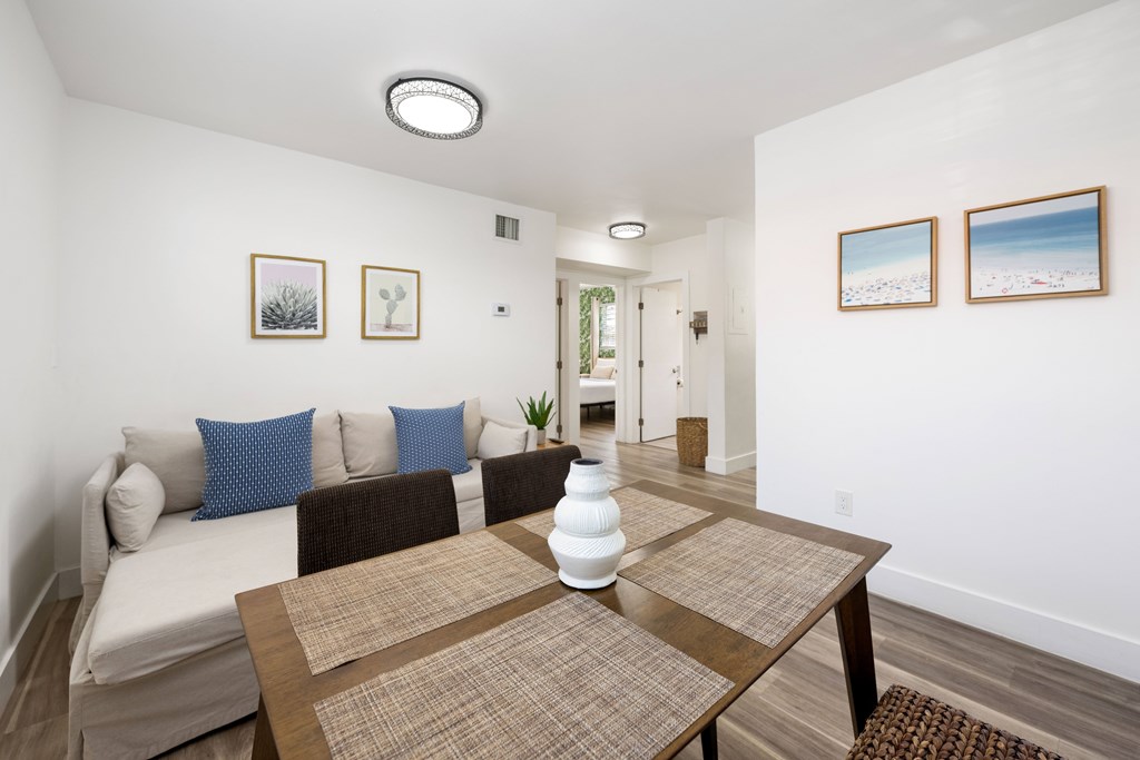 A dining room with a brown table and a white couch.