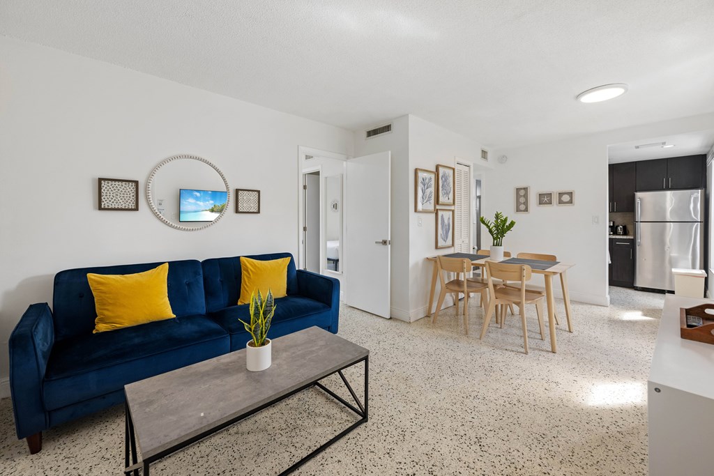 A living room with a blue couch and a coffee table.