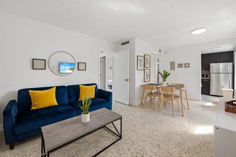 A living room with a blue couch and a coffee table.