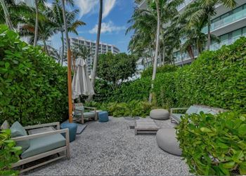 A garden with a gravel path and a white umbrella.